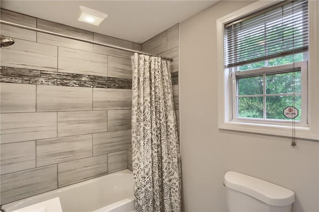 bathroom featuring shower / bath combination with curtain and toilet