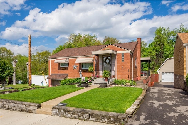 view of front of property featuring brick siding, an outdoor structure, a detached garage, a chimney, and a front yard