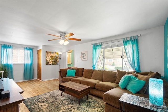 living area with ceiling fan, light wood-type flooring, and baseboards