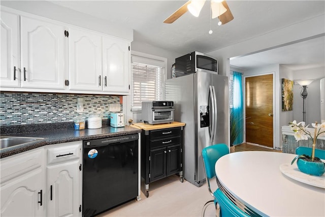 kitchen with appliances with stainless steel finishes, white cabinetry, ceiling fan, decorative backsplash, and dark countertops