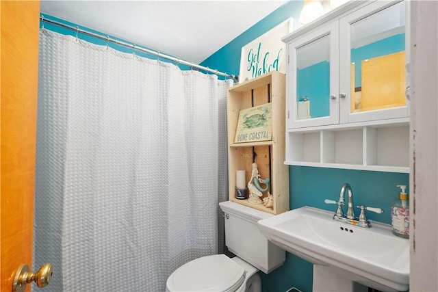 full bath featuring a sink, toilet, and curtained shower