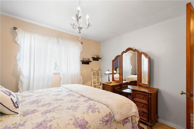bedroom featuring a chandelier and baseboards