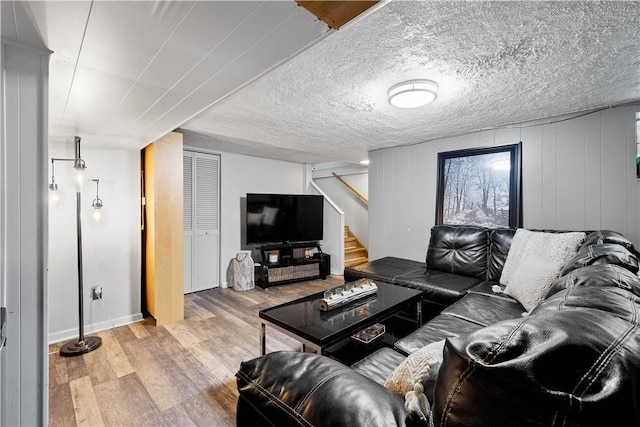 living area with wood finished floors and stairway