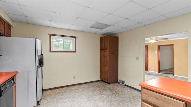 kitchen with fridge with ice dispenser, black dishwasher, a drop ceiling, light flooring, and baseboards