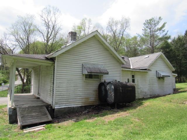 428 Grindstone Rd, Jefferson Twp Fay, PA 15442 - rear view of property featuring oil tank, a yard, and a chimney