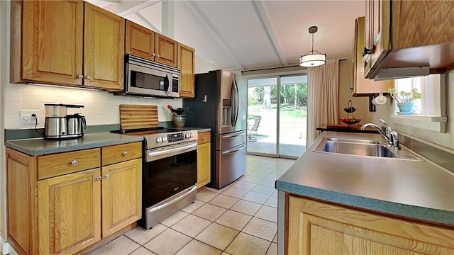 kitchen featuring appliances with stainless steel finishes, a sink, tasteful backsplash, light tile patterned flooring, and dark countertops