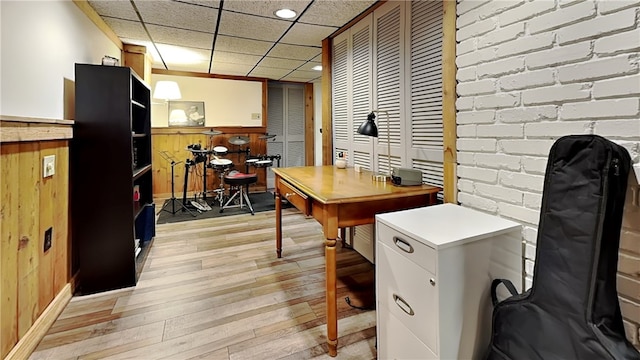 office featuring light wood-type flooring, wainscoting, and wood walls