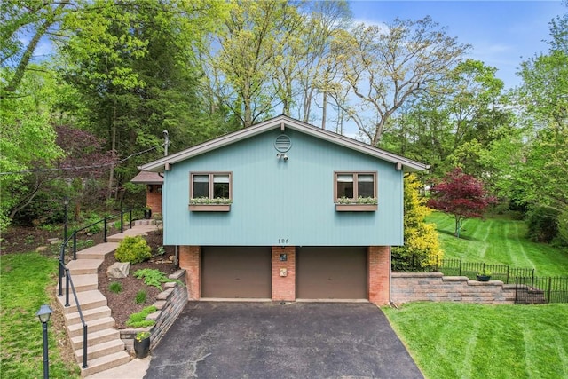 view of front of house with asphalt driveway, a garage, brick siding, and stairs