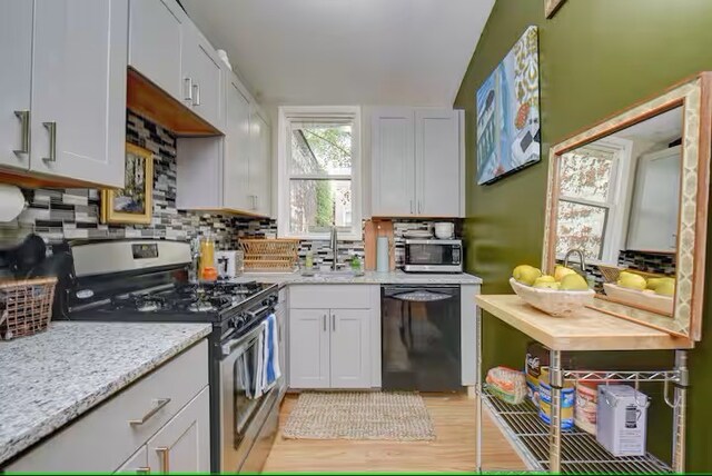 185 42nd St, Lawrenceville, PA 15201 - kitchen with stainless steel appliances, a sink, decorative backsplash, light stone counters, and light wood-style floors