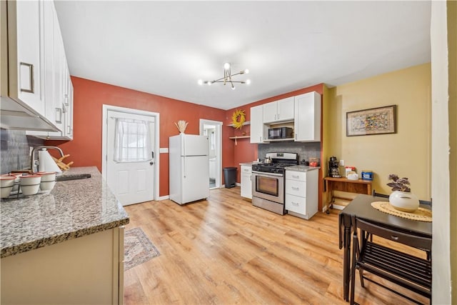 1851/2 42nd St, Lawrenceville, PA 15201 - kitchen featuring gas stove, freestanding refrigerator, a sink, light wood-type flooring, and white cabinetry
