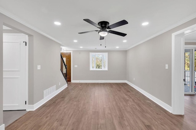 unfurnished living room with plenty of natural light, stairs, wood finished floors, recessed lighting, and ornamental molding