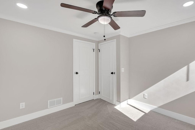carpeted spare room with ceiling fan, recessed lighting, baseboards, and crown molding