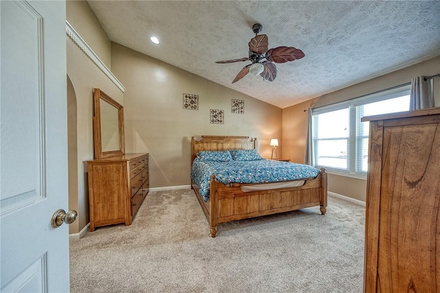 bedroom featuring lofted ceiling, carpet floors, a textured ceiling, baseboards, and a ceiling fan