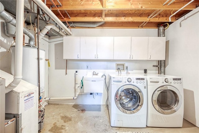 laundry area featuring washer and dryer, cabinet space, and gas water heater