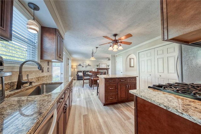 kitchen featuring a sink, light wood-type flooring, freestanding refrigerator, ornamental molding, and a ceiling fan