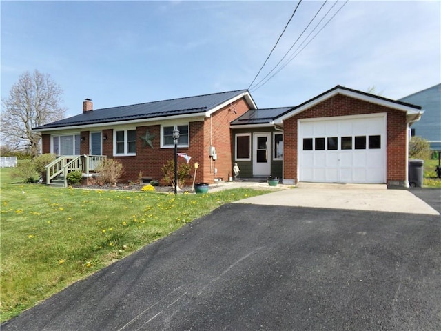 959 E Main St, Somerset Boro, PA 15501 - ranch-style home featuring a garage, a chimney, brick siding, asphalt driveway, and a front lawn