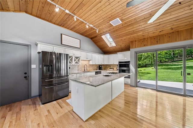 kitchen with fridge with ice dispenser, track lighting, wooden ceiling, vaulted ceiling, and white cabinetry