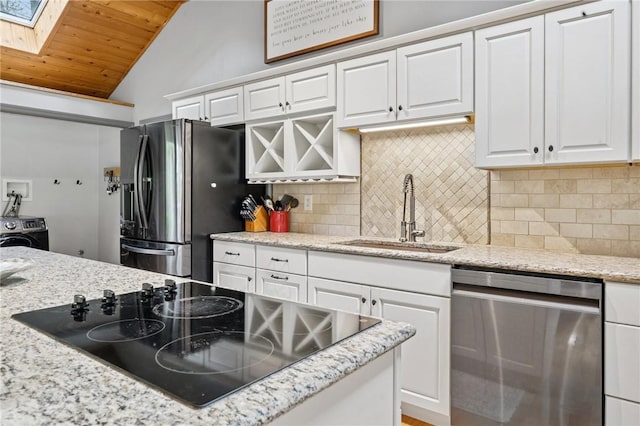 kitchen featuring stainless steel appliances, a sink, wood ceiling, lofted ceiling, and washer / clothes dryer