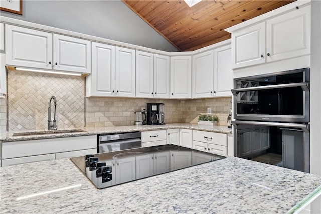 kitchen with a sink, lofted ceiling, wood ceiling, appliances with stainless steel finishes, and white cabinetry