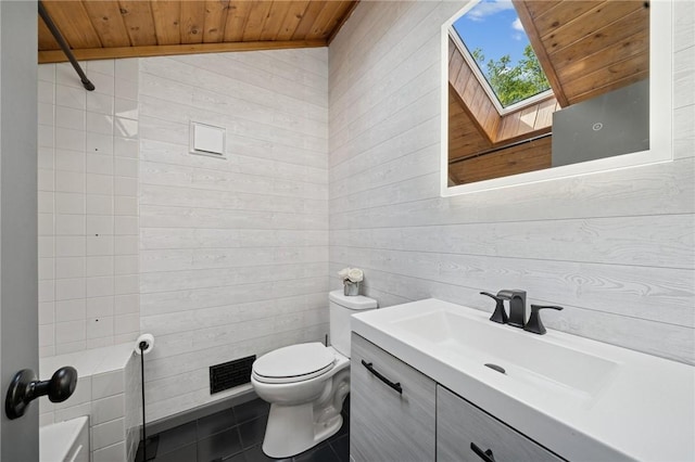 full bathroom with wood ceiling, wooden walls, a skylight, tile patterned flooring, and toilet