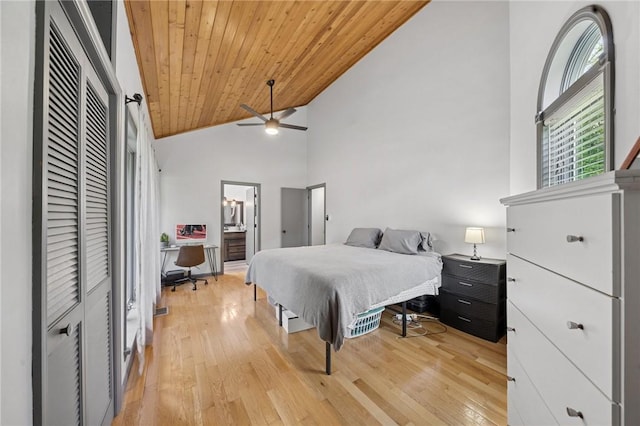 bedroom with an office area, light wood-style floors, wooden ceiling, high vaulted ceiling, and ensuite bath