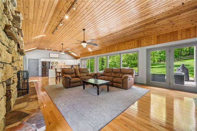 living room featuring track lighting, vaulted ceiling, healthy amount of natural light, wood ceiling, and ceiling fan