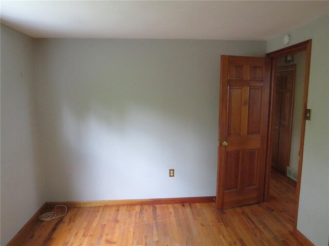 spare room with wood finished floors and baseboards