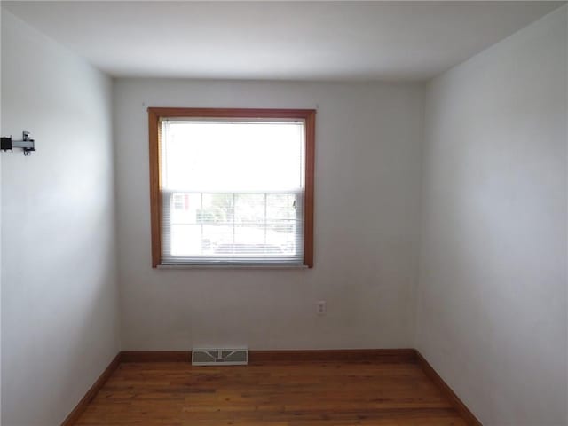 empty room with wood finished floors and baseboards