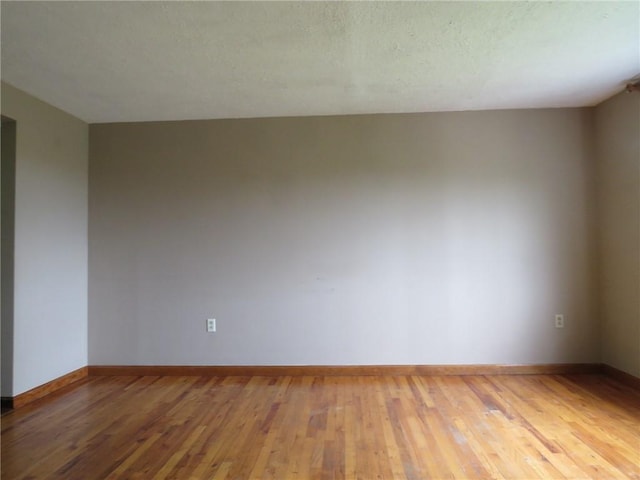 unfurnished room with wood-type flooring and baseboards