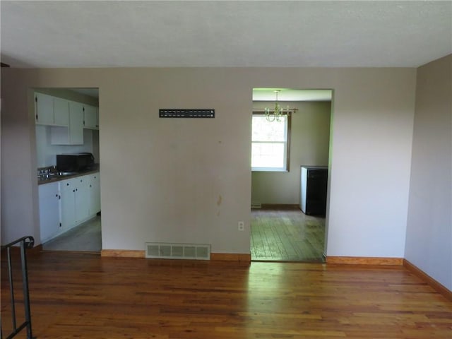 973 Glen Hayes Dr, Moon/Crescent Twp, PA 15046 - spare room featuring wood finished floors, a chandelier, and baseboards