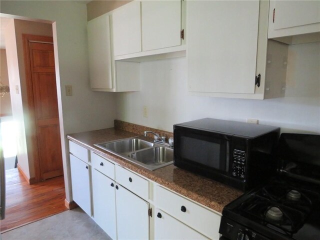 973 Glen Hayes Dr, Moon/Crescent Twp, PA 15046 - kitchen featuring gas range, black microwave, a sink, white cabinetry, and light wood finished floors