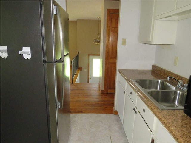 973 Glen Hayes Dr, Moon/Crescent Twp, PA 15046 - kitchen with freestanding refrigerator, a sink, and white cabinets