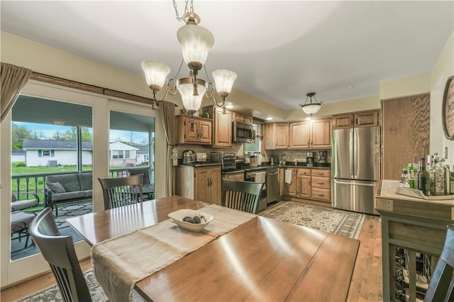 dining space with light wood finished floors and a chandelier