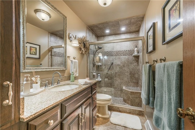 full bath with a stall shower, vanity, and toilet