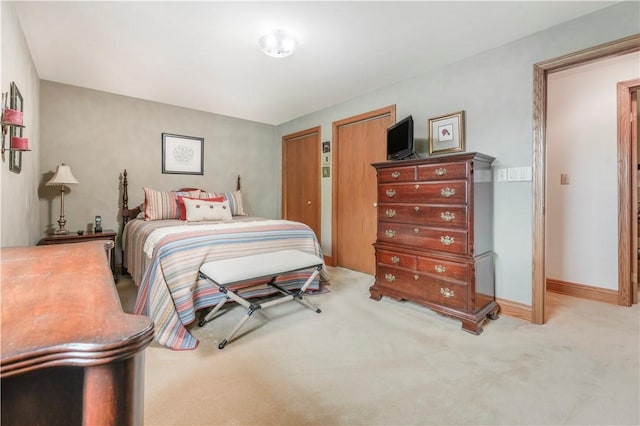 bedroom with carpet flooring, baseboards, and multiple closets