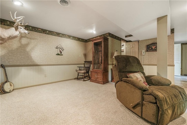 living area with wallpapered walls, carpet flooring, and wainscoting
