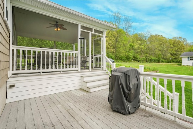 wooden terrace featuring ceiling fan, a lawn, a sunroom, and a grill
