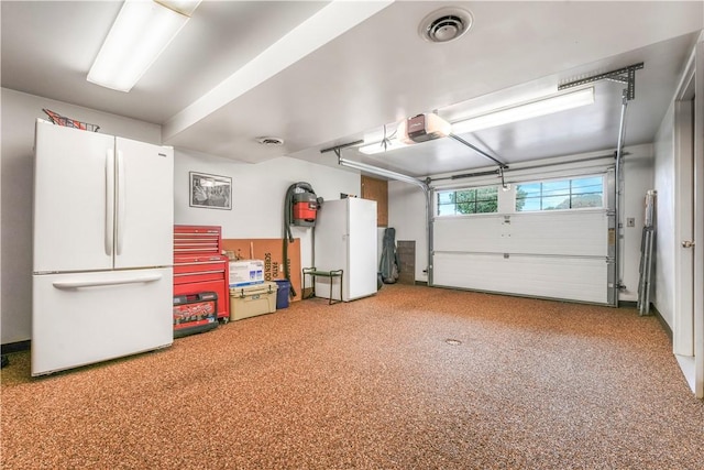 garage with freestanding refrigerator and a garage door opener