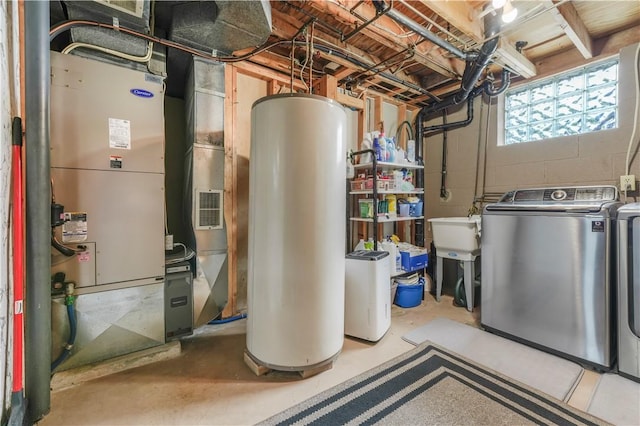 utility room with washing machine and clothes dryer, water heater, a sink, and heating unit