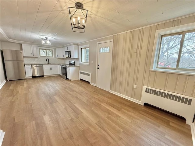 701 Mercer Rd, Twp Of But Nw, PA 16001 - kitchen with radiator heating unit, stainless steel appliances, light countertops, white cabinetry, and crown molding