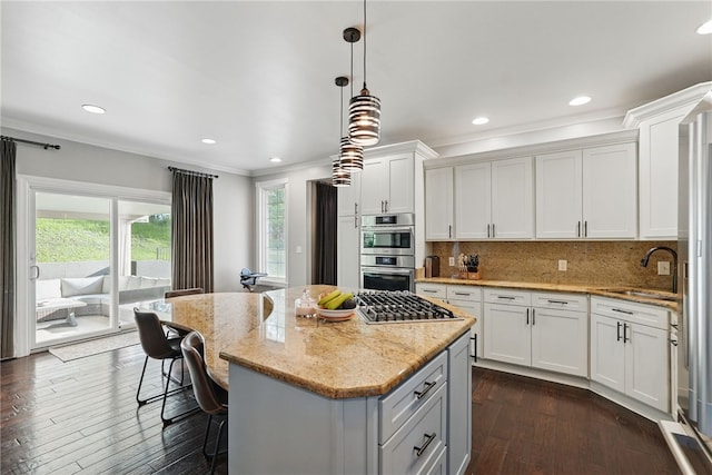 104 Ross Creek Ln, Peters Twp, PA 15367 - kitchen featuring ornamental molding, appliances with stainless steel finishes, backsplash, a center island, and light stone countertops