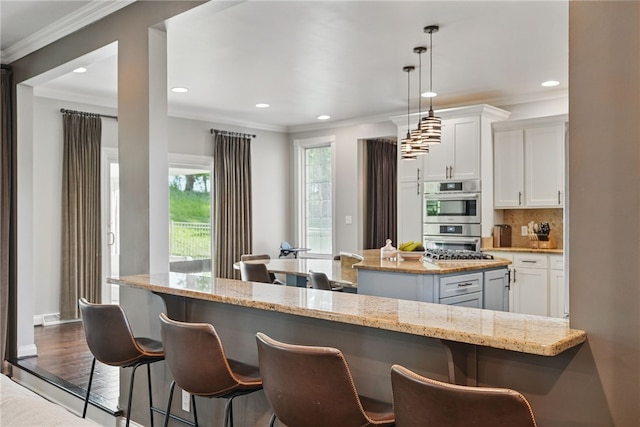 104 Ross Creek Ln, Peters Twp, PA 15367 - kitchen featuring stainless steel double oven, a breakfast bar area, recessed lighting, white cabinets, and crown molding