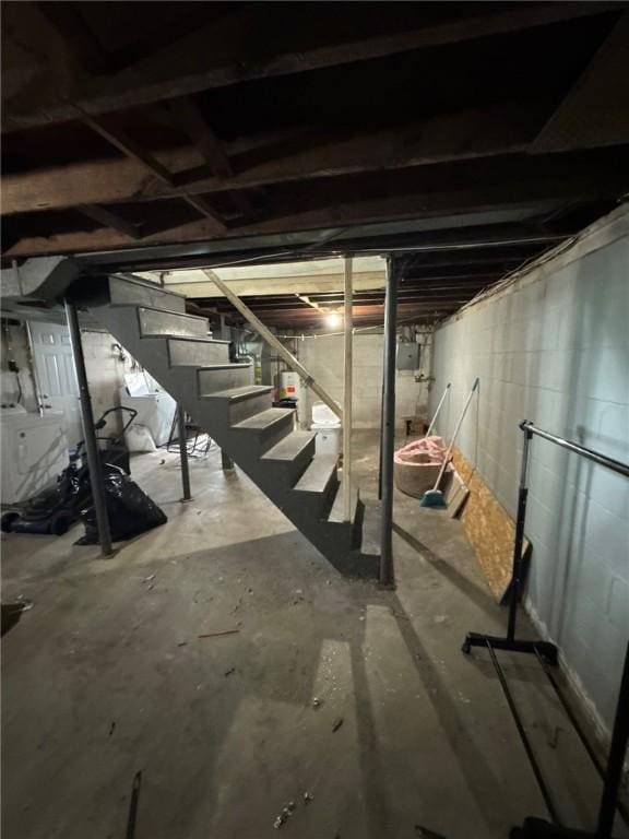 unfinished below grade area with stairway, washer and clothes dryer, and gas water heater