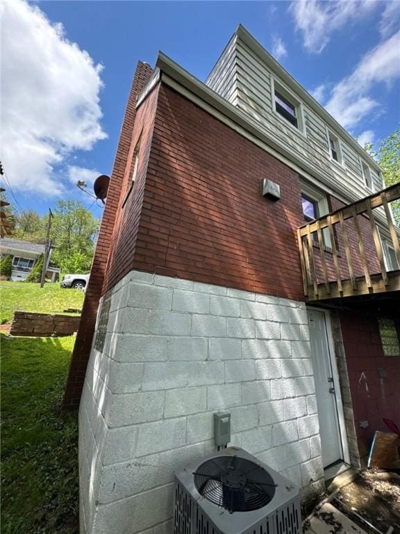 view of home's exterior featuring central air condition unit and a lawn
