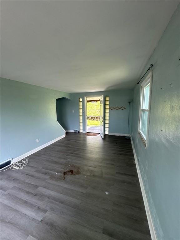 unfurnished living room with baseboards and wood finished floors