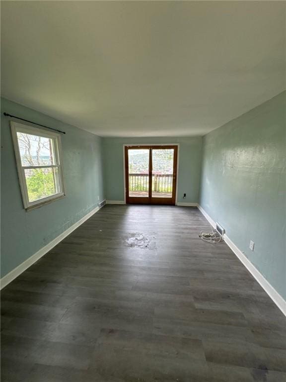 unfurnished room with dark wood-style floors and baseboards