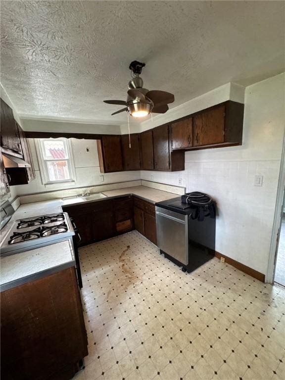 kitchen with light floors, dark brown cabinets, range, ceiling fan, and a textured ceiling