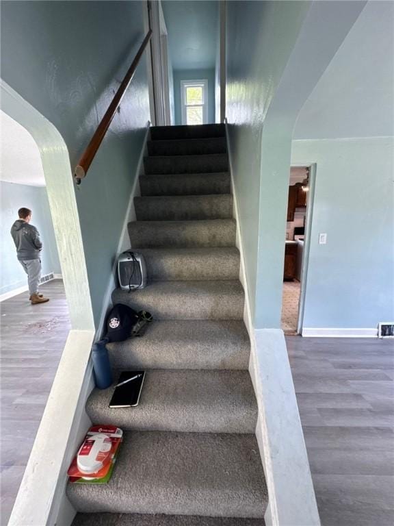 stairs featuring wood finished floors and baseboards
