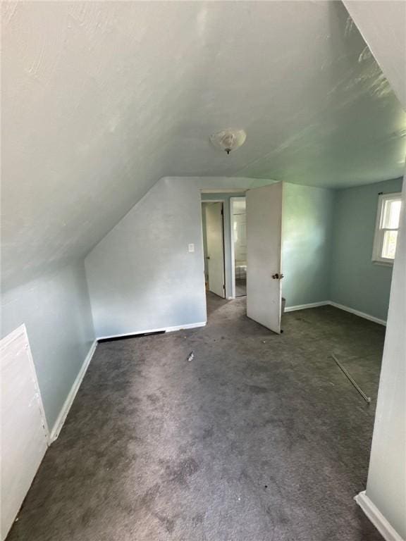 bonus room with baseboards and vaulted ceiling