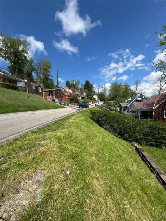 view of green lawn featuring a residential view